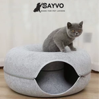 Grey cat sitting on a light grey donut-shaped cat tunnel bed with an enclosed circular tunnel and zippered detachable design.